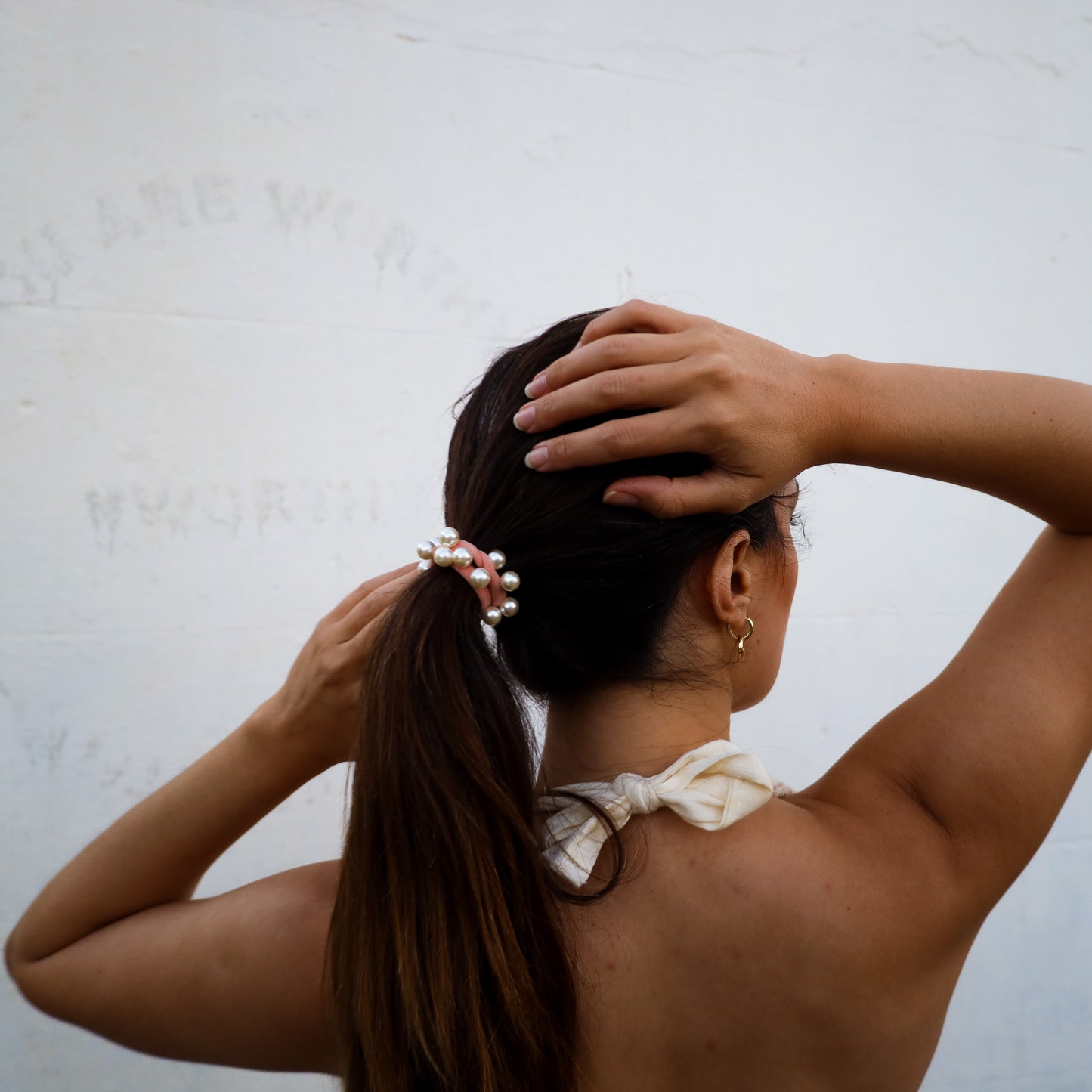 Woman with a ponytail against a plain background